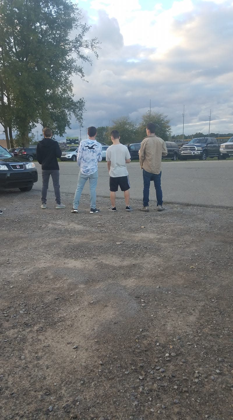 The four Bullock Creek High School students came to a halt to pay their respects as the national anthem sounded inside the Midland County, Mich., stadium. (Credit: Facebook/Mike Ullery Jr.)