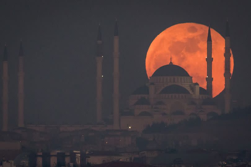 ISTANBUL, TURKEY - JANUARY 31, 2018:  A Super Blue Blood Moon rises behind the Camlica Mosque on January 31, 2018 in Istanbul, Turkey. A Super Blue Blood Moon is the result of three lunar phenomena happening all at once: not only it is the second full moon in January, but the moon will also be close to its nearest point to Earth on its orbit, and be totally eclipsed by the Earth's shadow. The last time these events coincided was in 1866, 152 years ago.  (Photo by Chris McGrath/Getty Images)