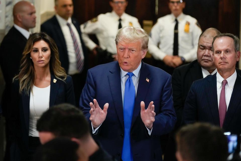 Former President Donald Trump, center, speaks to the media upon arriving at New York Supreme Court on Oct. 2, 2023, in New York. Trump is making a rare, voluntary trip to court in New York for the start of a civil trial in a lawsuit that already has resulted in a judge ruling that he committed fraud in his business dealing.