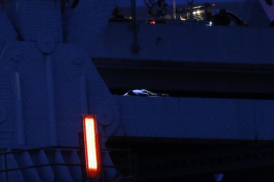 Sylvester Holt, bottom left, lays on a ledge of the Crescent City Connection Friday, Jan. 20, 2017, in New Orleans. Holt was wanted in the connection with the shooting of his wife and a Westwego police officer. (AP Photo/Jonathan Bachman)