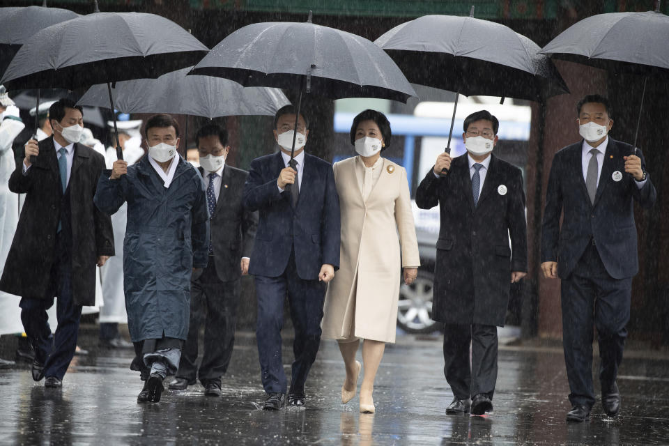 South Korean President Moon Jae-in, center left, and his wife Kim Jung-sook, center right, arrive to attend a ceremony to mark the 102nd anniversary of the March First Independence Movement Day, the anniversary of the 1919 uprising against Japanese colonial rule in Seoul, South Korea, Monday, March 1, 2021. (Jewon Heon-kyun/Pool Photo via AP)