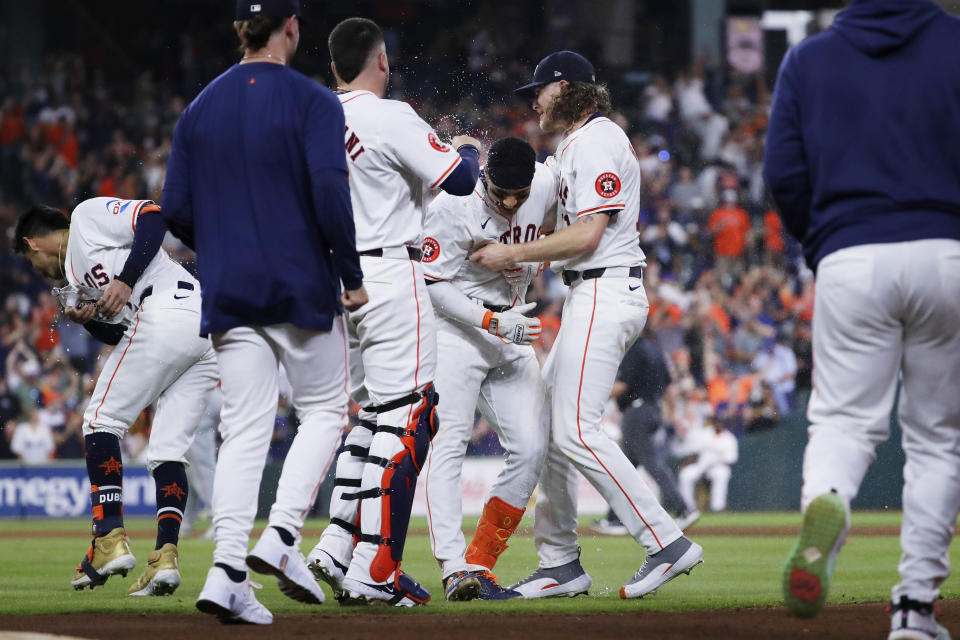 Houston Astros' Victor Caratini, center left, and Josh Hader, center right, celebrate by pouring water onto Jeremy Peña, who singled in the winning run against the Los Angeles Angels in the 10th inning of a baseball game Tuesday, May 21, 2024, in Houston. (AP Photo/Michael Wyke)