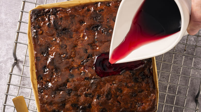 Pouring alcohol over fruitcake