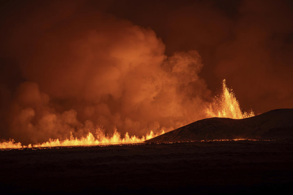 Lava fountains are seen as volcanic eruption started, turning the sky orange, in Grindavik on Iceland's Reykjanes Peninsula, Monday, Dec. 18, 2023. (AP Photo/Marco Di Marco)