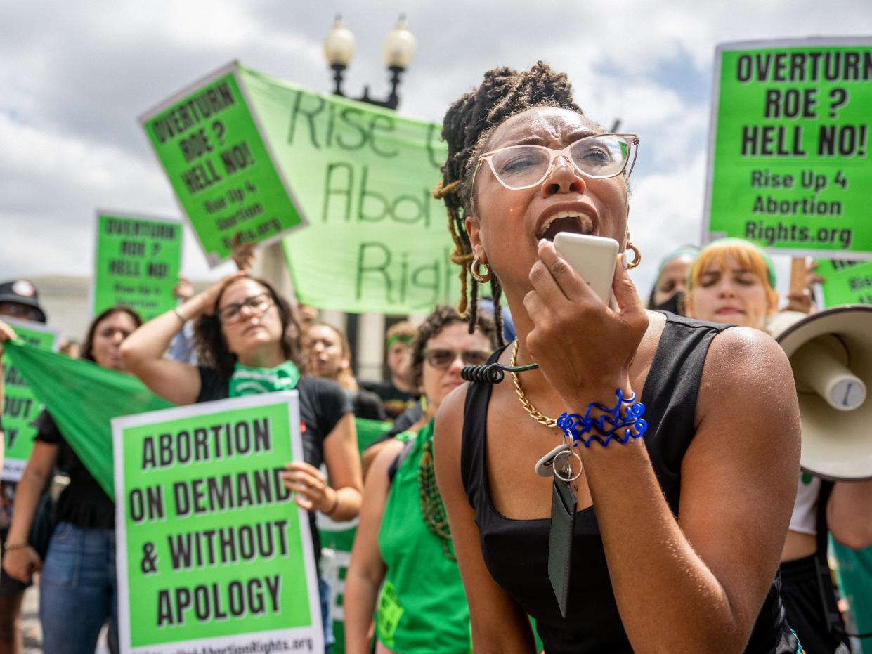 A woman shouts into a megaphone at a protest for abortion rights