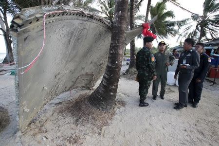 Thai army members stand next to a piece of suspected plane wreckage which has been found off the coast of southern Thailand in Nakhon Si Thammarat province, January 24, 2016. REUTERS/Surapan Boonthanom?