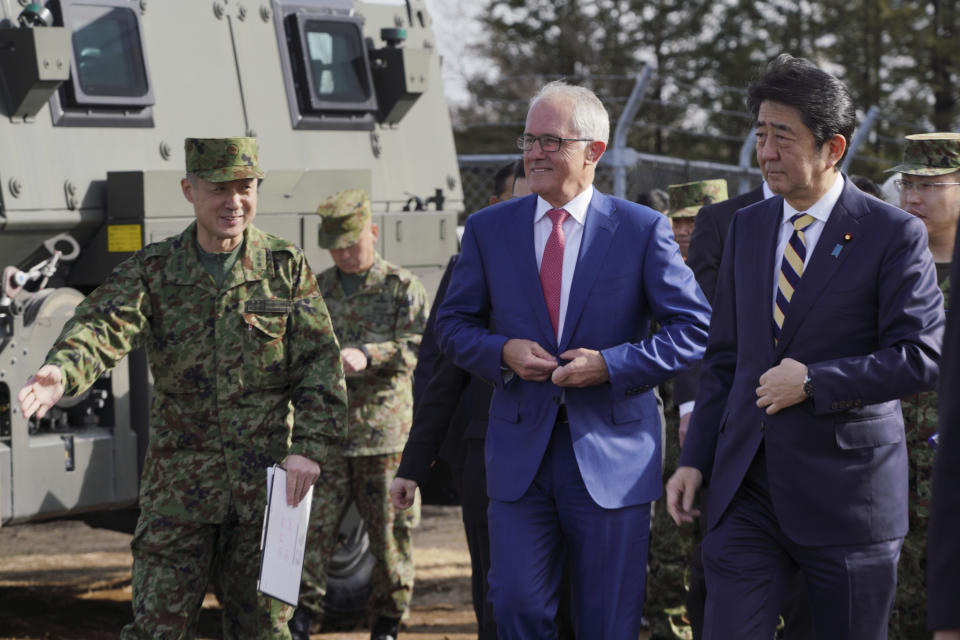 FILE - Australian Prime Minister Malcolm Turnbull, center, and Japanese counterpart Shinzo Abe, right, are briefed by a Japan Ground Self-Defense Force officer on a surface-to-air Patriot Advanced Capability-3 (PAC-3) missile interceptor launcher vehicle and a Bushmaster Protected Mobility Vehicle at Narashino Exercise Area in Funabashi, Chiba Prefecture, east of Tokyo on Jan. 18, 2018. Australia will be represented by its government leader plus three former leaders at Abe’s state funeral this month in an extraordinary mark of respect for Japan’s longest-serving prime minister. Prime Minister Anthony Albanese said on Thursday, Sept. 8, 2022, that former Prime Ministers Turnbull, John Howard and Tony Abbott would join Australia’s official delegation.(AP Photo/Eugene Hoshiko, File)