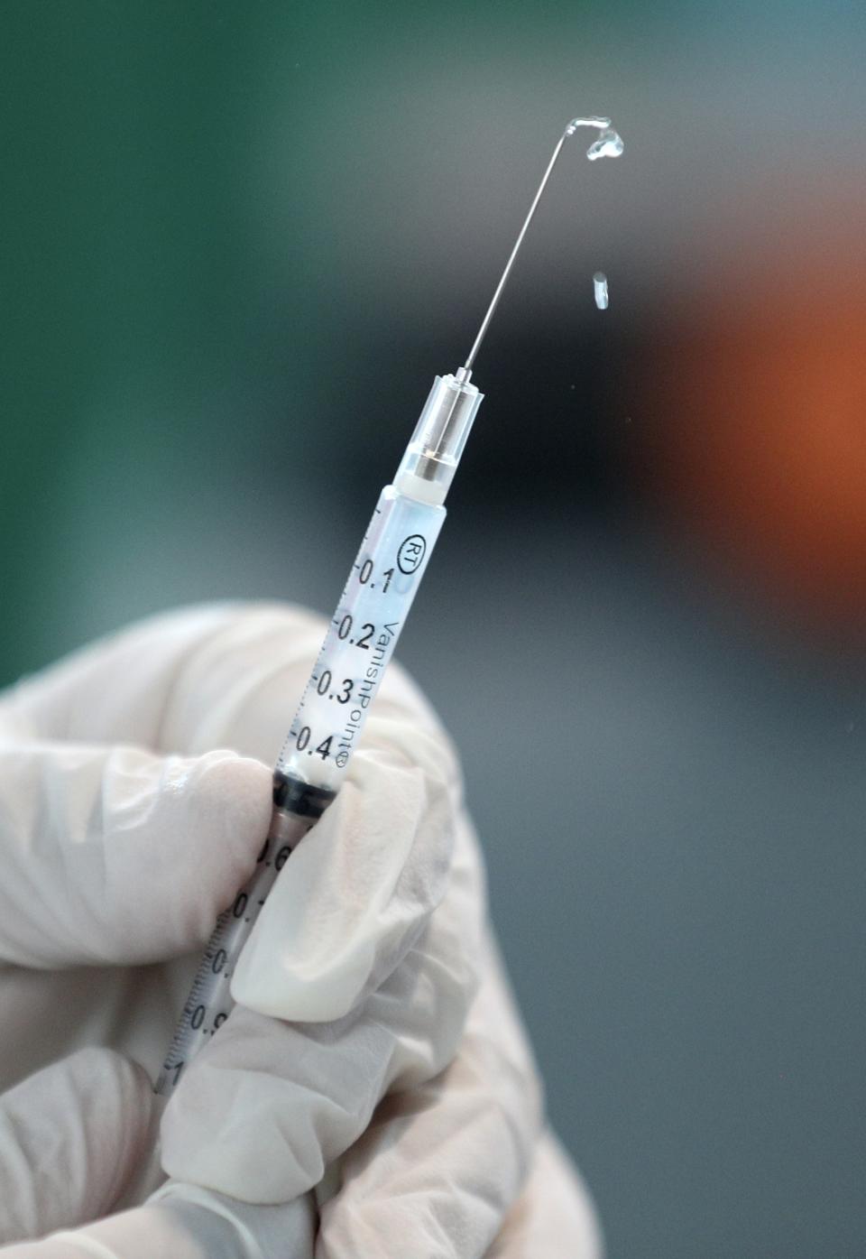 A doctor prepares a dose of China's Sinopharm vaccine during a priority COVID-19 vaccination of health workers at a public hospital in Lima, Peru, Wednesday, Feb. 10, 2021. Peru received its first shipment of COVID-19 vaccines on Sunday night. (AP Photo/Martin Mejia)