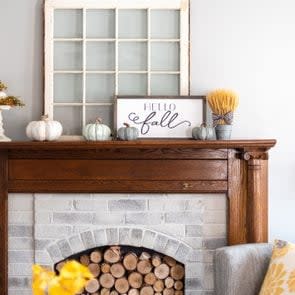 Stylish fall home decorations on a mantel in a living room