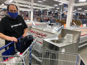 In this Tuesday, March 31, 2020, photo comedian Frank De Lima wears a mask and maintains social distancing while shopping at a Honolulu Sam's Club store in Honolulu. People in Hawaii are changing how they express aloha in the time of coronavirus. Some residents say social distancing is the antithesis of tradition in the state, where people greet each other with hugs, kisses and lei, and families are close-knit. (AP Photo/Jennifer Sinco Kelleher)