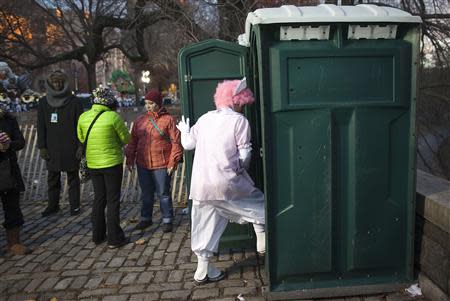 A clown uses a portable toilet before the 87th Macy's Thanksgiving day parade in New York November 28, 2013. REUTERS/Carlo Allegri