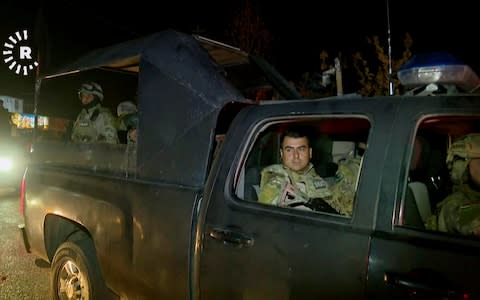 This image made from a video provided by RUDAW TV shows what the Irbil-based Kurdish broadcaster says are Peshmerga fighters and volunteers arriving on military trucks in Kirkuk, - Credit: AP