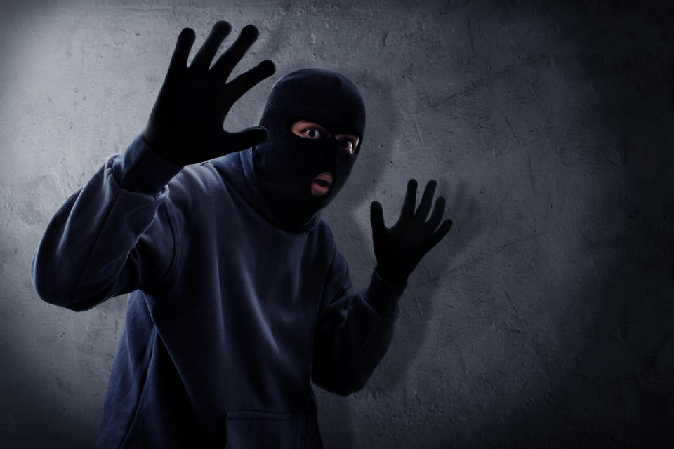 a burglar in a ski mask and gloves
