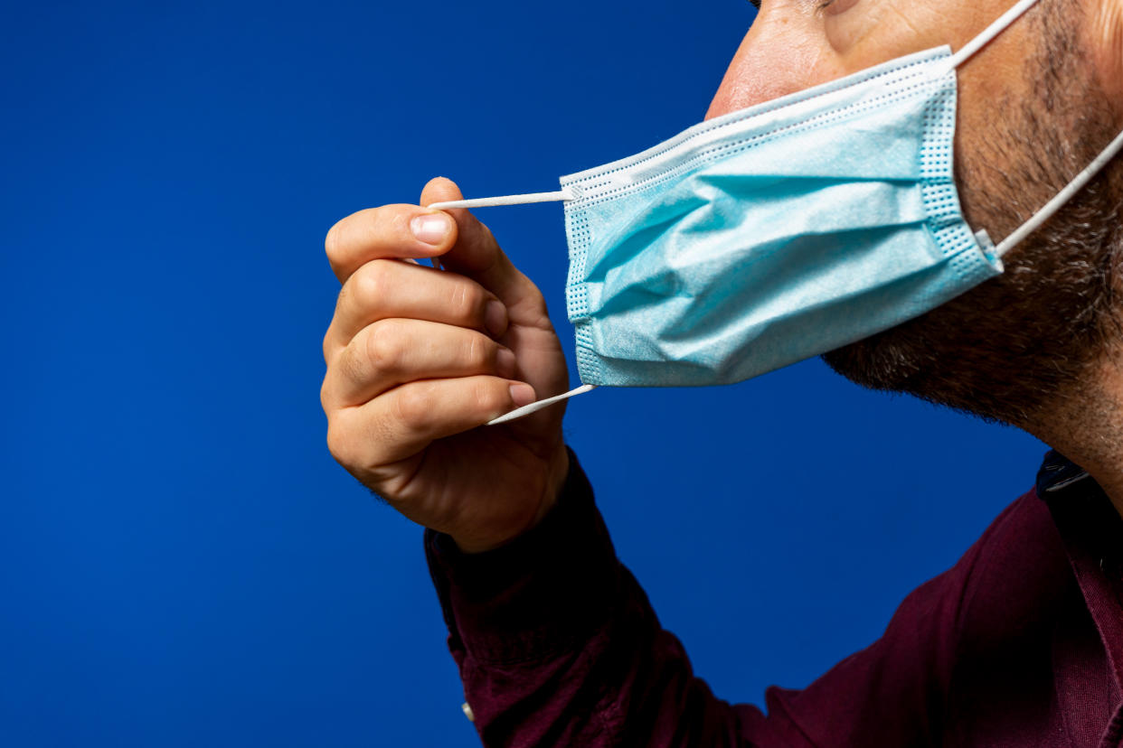 A photo showing a man taking off a face mask. (Getty Images file photo)