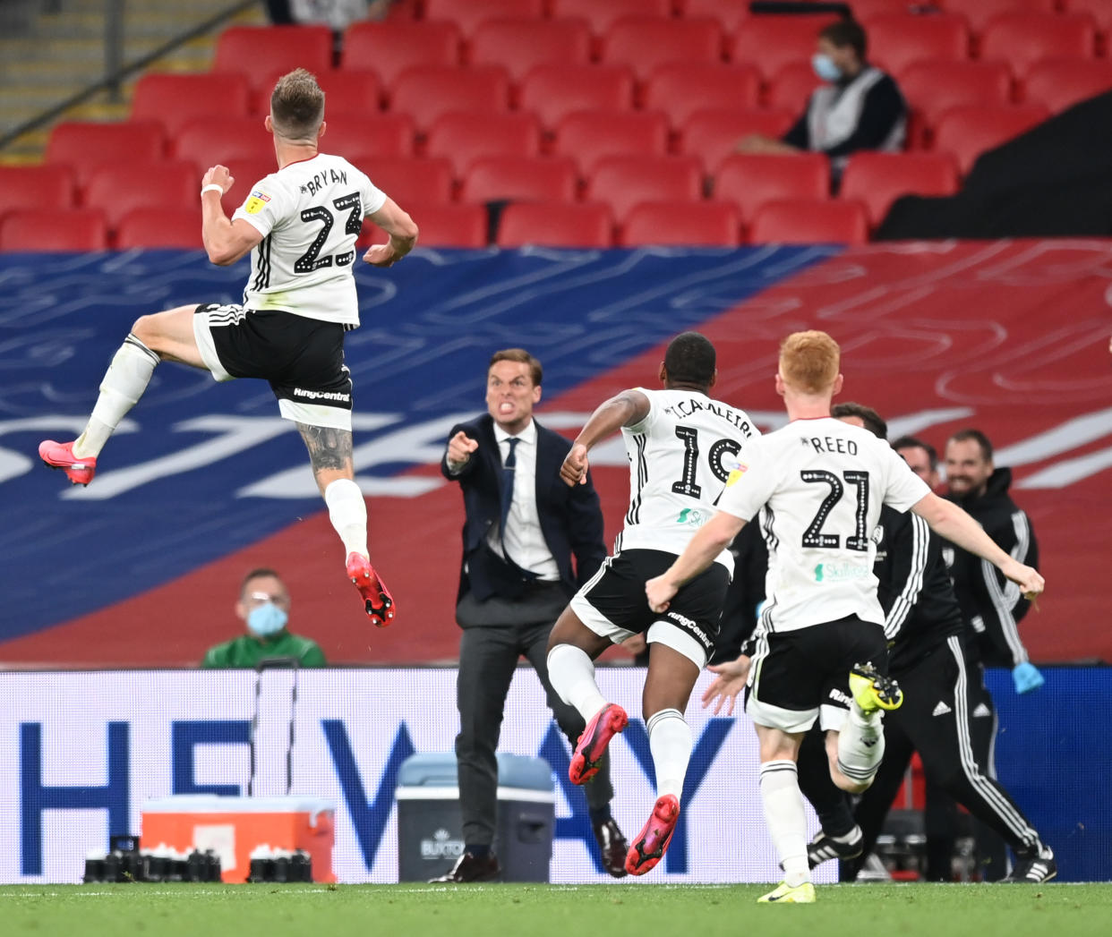 Joe Bryan (top left) and his Fulham teammates and coaches celebrate the journeyman fullback's extra-time game-winning goal that took the club back to the Premier League. (Shaun Botterill/Getty Images)