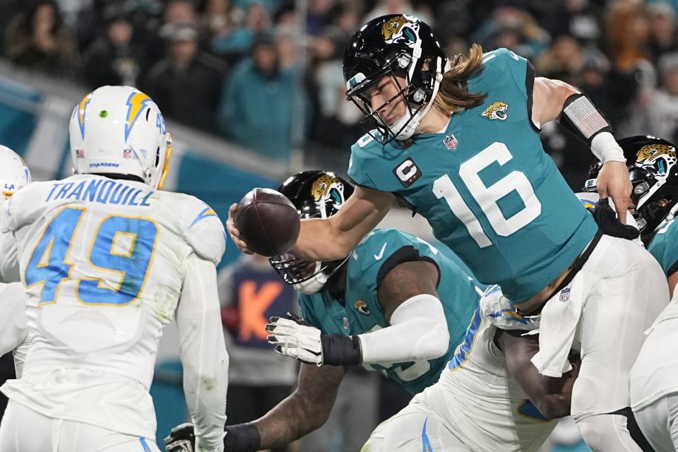 Jacksonville Jaguars quarterback Trevor Lawrence (16) leaps for a two-point conversion against the Los Angeles Chargers during the second half of an NFL wild-card football game, Saturday, Jan. 14, 2023, in Jacksonville, Fla. (AP Photo/Chris Carlson)