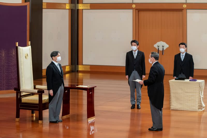 Japan's Emperor Naruhito stands before new Prime Minister Yoshihide Suga, as former prime minister Shinzo Abe looks on, during Suga's attestation ceremony at the Imperial Palace in Tokyo