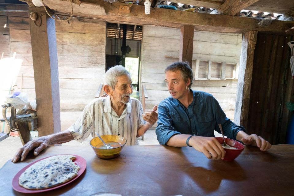 Dan Buettner (right) speaking with a centenarian, a person who has reached the age of 100 years.