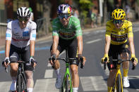 Denmark's Jonas Vingegaard, wearing the overall leader's yellow jersey and who also has the best climber's dotted jersey, Belgium's Wout van Aert of Belgium, wearing the best sprtinters green jersey, and Slovenia's Tadej Pogacar, wearing the best young rider's white jersey, ride during the twenty-first stage of the Tour de France cycling race over 116 kilometers (72 miles) with start in Paris la Defense Arena and finish on the Champs Elysees in Paris, France, Sunday, July 24, 2022. (AP Photo/Thibault Camus)