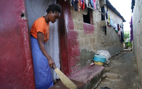 Mirriam, a young mother who lost one of her children to cholera, sweeps outside her home in Garden Compound. Lusaka, Zambia, May 2018. - Credit: Chileshe Chanda/WaterAid