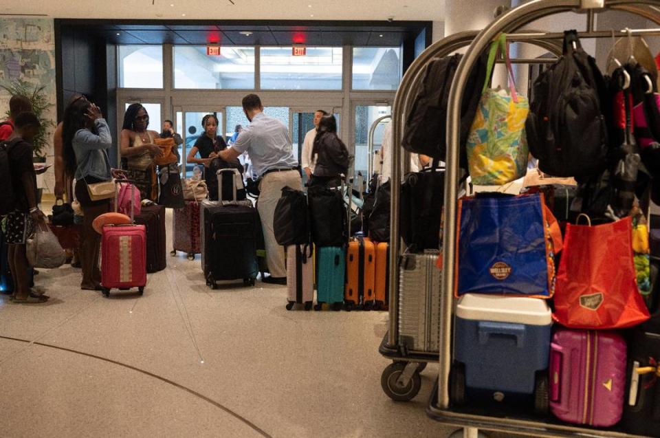 People wait in line to check out Aug. 17, 2023 in the lobby at Loews Miami Beach Hotel.