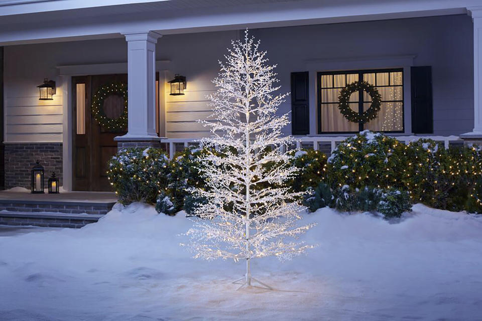 This image provided by The Home Depot shows a white lighted tree. A tree like this one from Home Depot, brings the season home in a welcoming way when placed near the front door. Keep it simple by accenting with natural greenery or go bold with the addition of colorful spotlights and ornaments. (The Home Depot via AP)