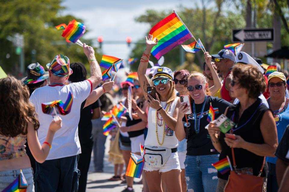 A crowd of parade-goers wave during the Palm Beach Pride Parade, held on Sunday, March 26, 2023, in downtown Lake Worth Beach, FL.