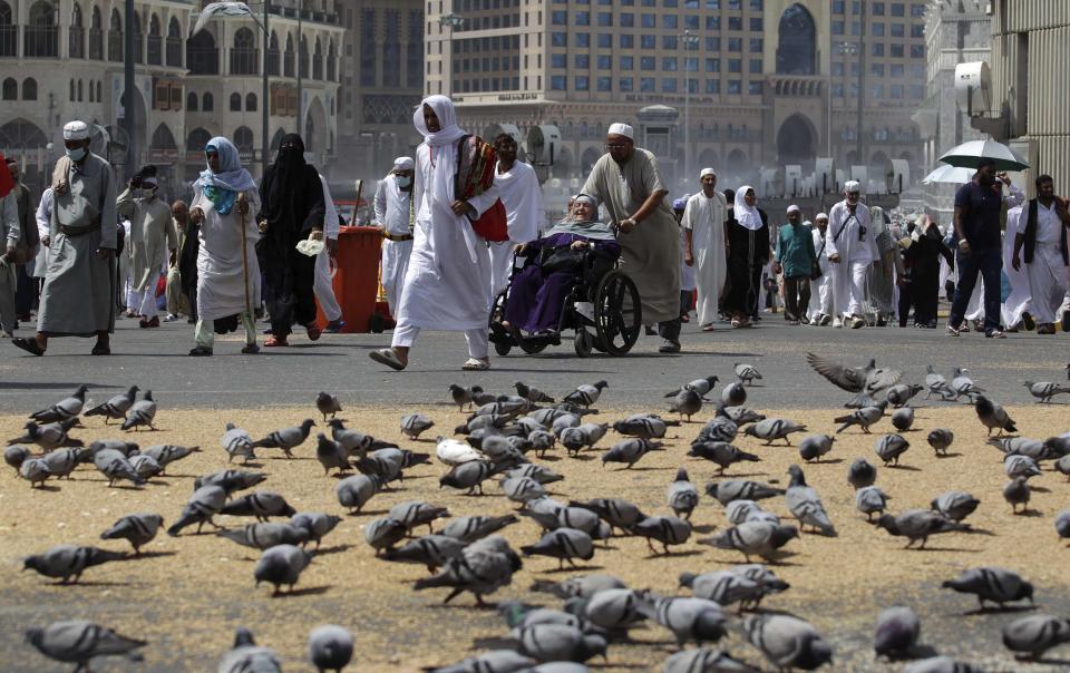 Muslim pilgrims walk past pigeons near the Grand Mosque in Mecca, ahead of the annual haj pilgrimage