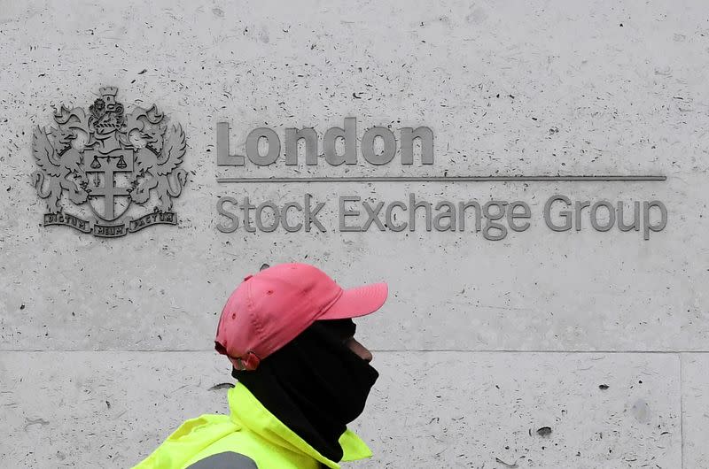 FILE PHOTO: A street cleaning operative walks past the London Stock Exchange Group building in the City of London financial district, whilst British stocks tumble as investors fear that the coronavirus outbreak could stall the global economy, in London