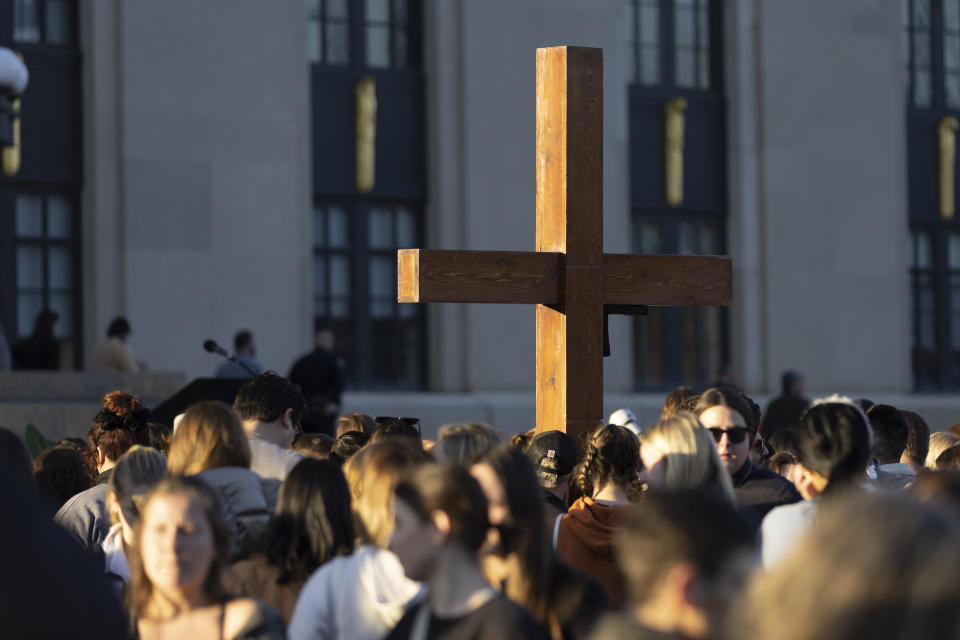 A cross stands above the crowd during a vigil held for victims of The Covenant School shooting on Wednesday, March 29, 2023, in Nashville, Tenn. (AP Photo/Wade Payne)