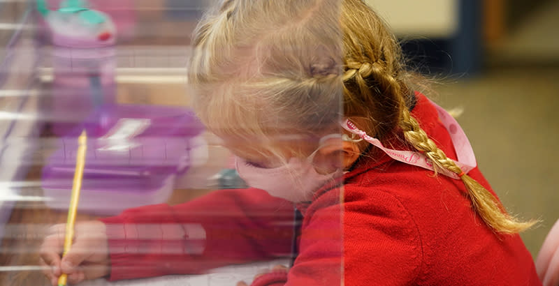 A kindergarten student does her work behind a shield at Freedom Preparatory Academy on September 10, 2020 in Provo, Utah. - In person schooling with masks has started up in many Utah schools since shutting down in March of this year due to the covid-19 virus.