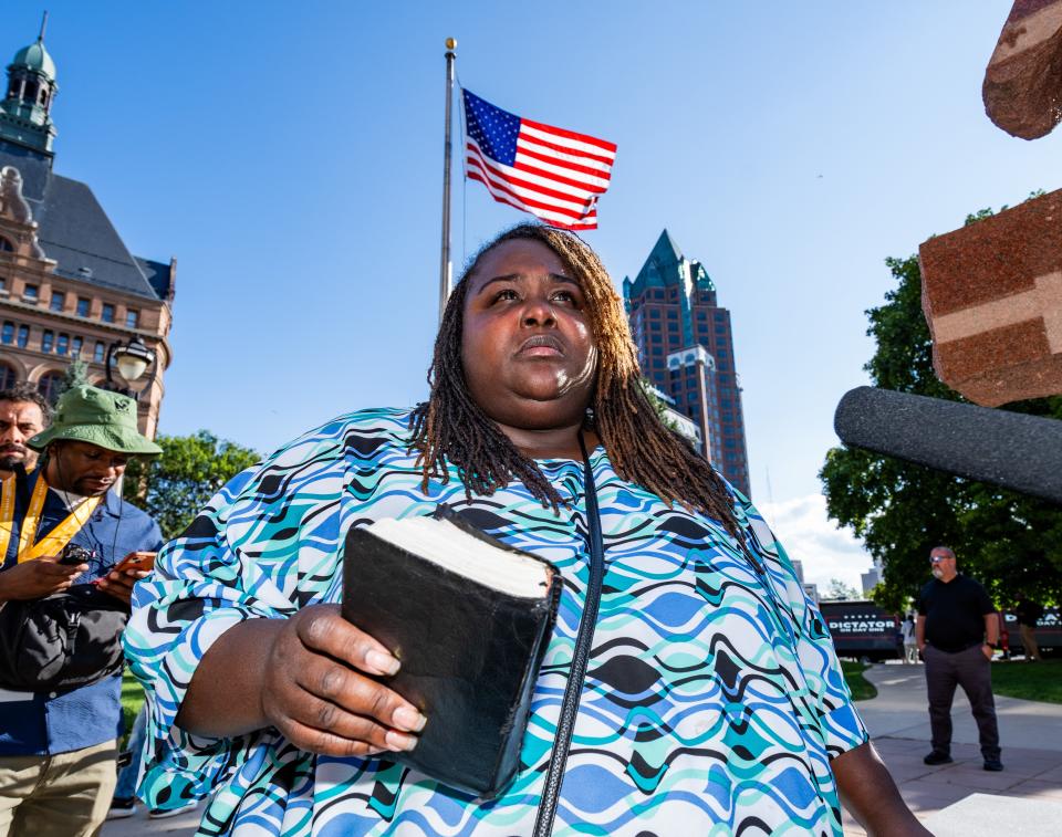 Angelique Sharpe, sister of Samuel Sharpe Jr., holds her brother’s Bible as she speaks to the press after a rally at Red Arrow Park on Thursday in Milwaukee.