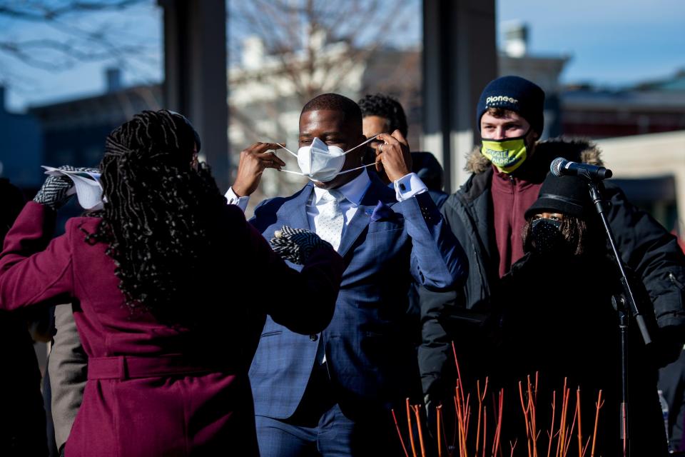 Reggie Harris puts his mask on after being sworn in as a Cincinnati city council member at the inaugural session of the city council held at Washington Park in Over-the-Rhine on Tuesday, Jan. 4, 2022.