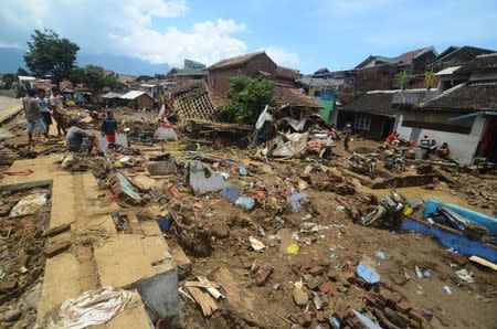 Residents survey an area damaged by a flash flood in Garut, West Java, Indonesia September 21, 2016 in this photo taken by Antara Foto. Antara Foto/Adeng Bustomi/ via REUTERS