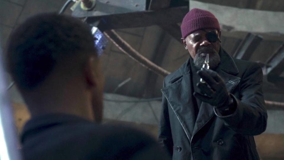 Nick Fury holds a vial up to Gravik seated on the ground on Secret Invasion