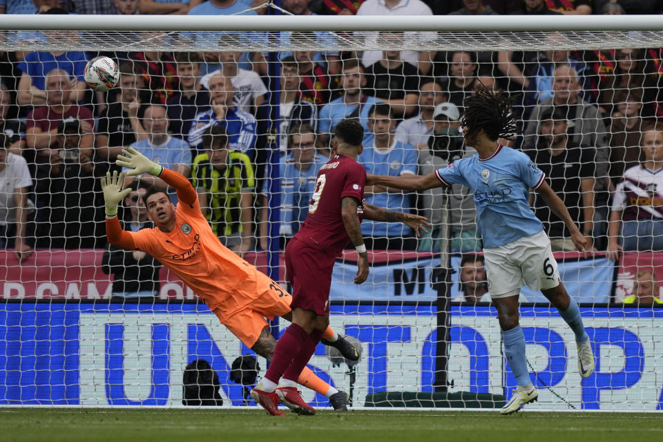 Manchester City's goalkeeper Ederson, left, fails to save the ball as Liverpool's Trent Alexander-Arnold scores his side's opening goal during the FA Community Shield soccer match between Liverpool and Manchester City at the King Power Stadium in Leicester, England, Saturday, July 30, 2022. (AP Photo/Frank Augstein)