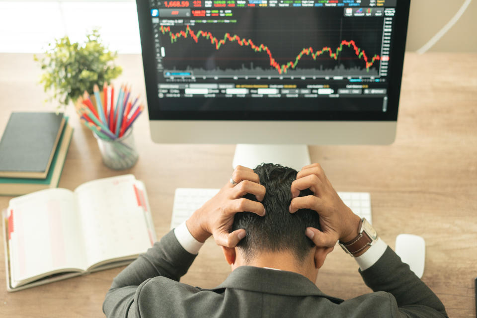 Businessman grabs the head concept with business chart on scoreboard