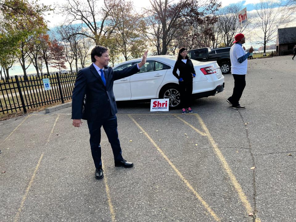 Then-Democratic candidate for the 13th Congressional District Shri Thanedar waves to voters headed to vote in Grosse Pointe Park at the Lavins Activity Center on Nov. 8, 2022. His wife, Shashi, and supporter Wendell Smiley, of Detroit, were with the candidate showing their support.