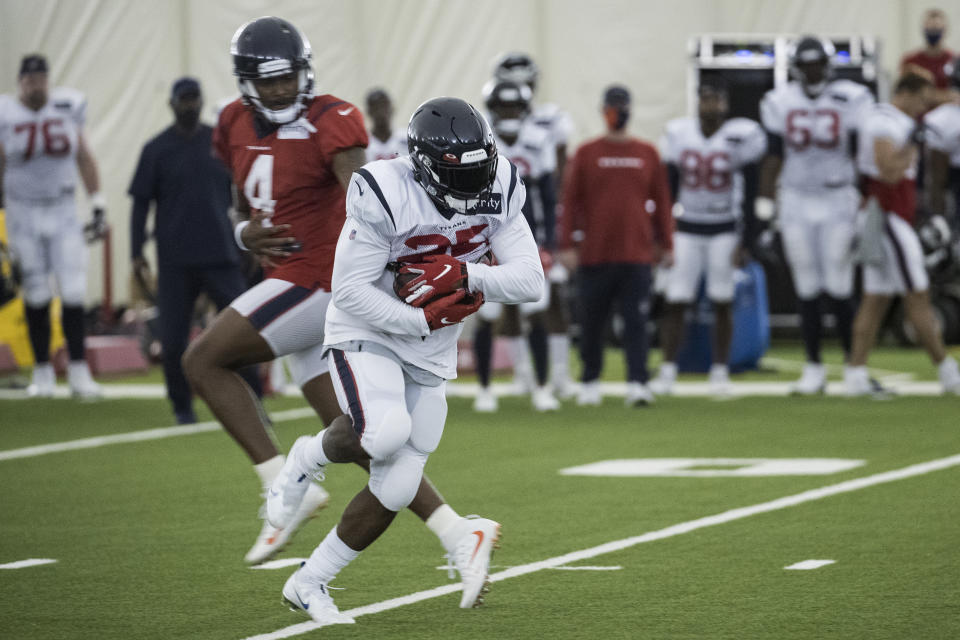 Houston Texans running back Duke Johnson (25) takes a handoff from quarterback Deshaun Watson (4) during an NFL training camp football practice Friday, Aug. 14, 2020, at The Houston Methodist Training Center in Houston. (Brett Coomer/Houston Chronicle via AP)