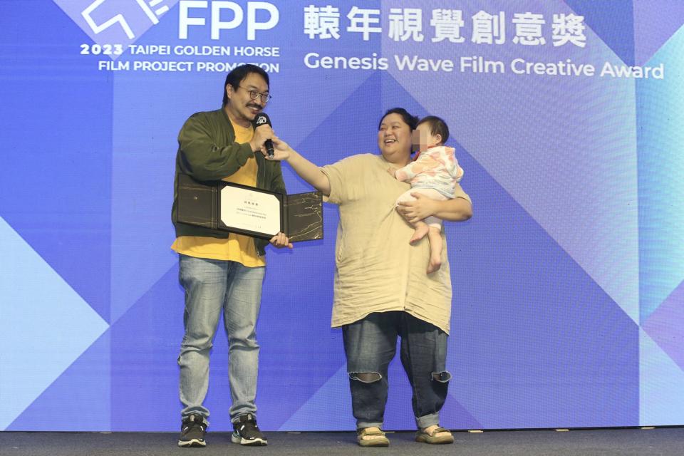 女星蔡嘉茵（右）抱著女兒，與劇場導演老公樊宗錡（左）一起代表《阿嬤愛你》上台領獎。