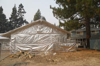 FILE - In this Sept. 1, 2021 file photo Martin Diky's home completely wrapped in fire-resistant material to protect the property against the approaching Caldor Fire in Meyers, Calif. Diky decided to order $6,000 worth of aluminum protective covering to wrap his home near Lake Tahoe in June as the last big wildfire roared through the Sierra dozens of miles southwest of the forested alpine waters. (AP Photo/Jae C. Hong,File)