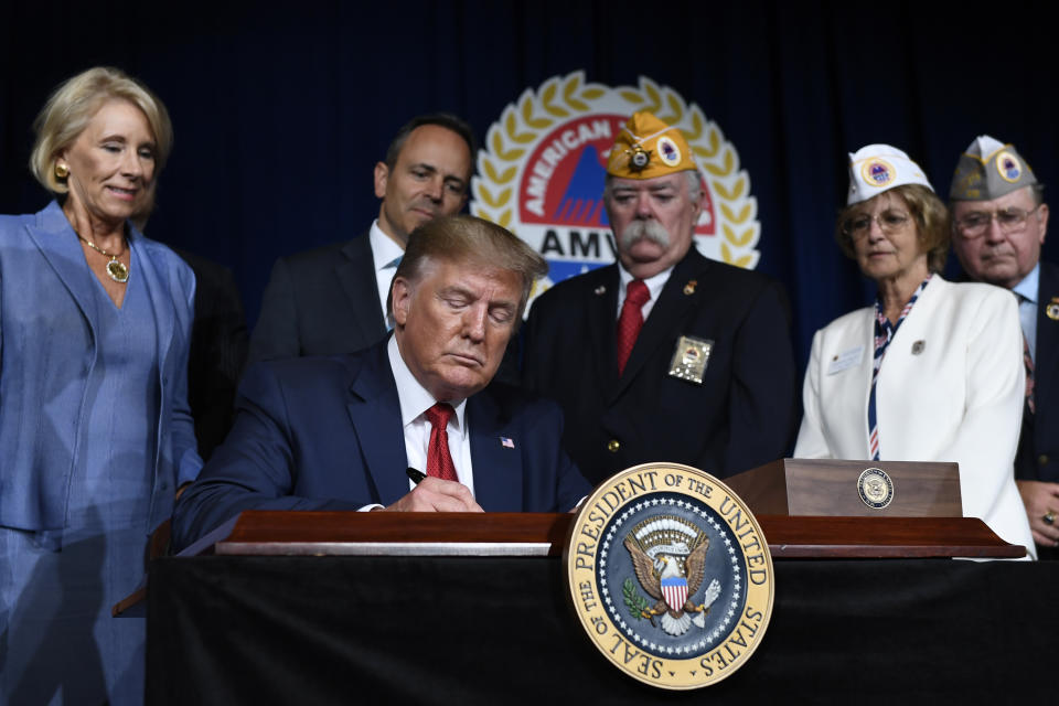 President Donald Trump signs a presidential memorandum that discharges the federal student loan debt of totally and permanently disabled veterans following his speech at the American Veterans (AMVETS) 75th National Convention in Louisville, Ky., Wednesday, Aug. 21, 2019. (AP Photo/Susan Walsh)