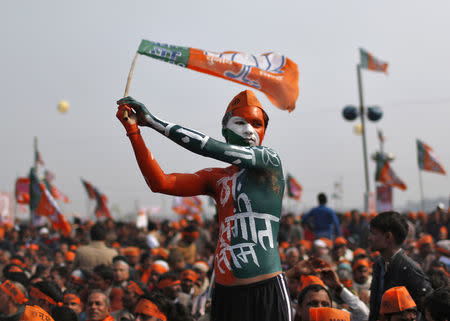 A supporter of India's main opposition Bharatiya Janata Party (BJP) waves the party's flag during a rally being addressed by Gujarat's Chief Minister and Hindu nationalist Narendra Modi, the prime ministerial candidate for BJP, ahead of the 2014 general elections, at Meerut in Uttar Pradesh February 2, 2014. REUTERS/Ahmad Masood/File Photo