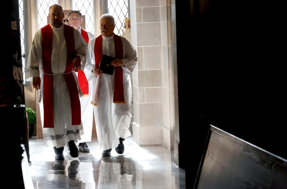 Priests head into the Cathedral of the Most Blessed Sacrament in Detroit on Jan. 14, 2023, before the start of a mass honoring Pope Benedict.