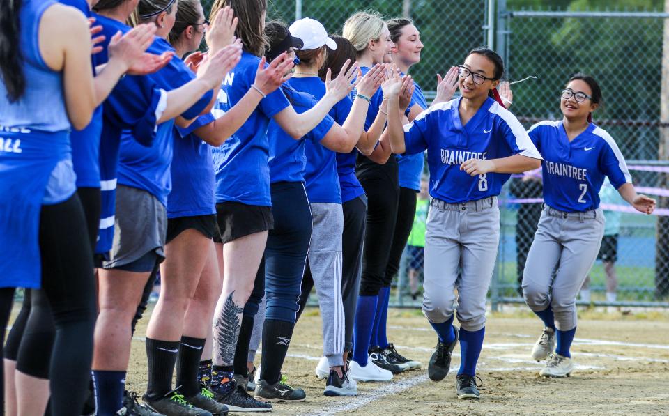 Braintree High's Catherine (8) and Jaclyn McPhee run through the line of high-fives during the "Hope at Bat" alumni game hosted by the Braintree High softball team on Friday, May 20, 2022.
