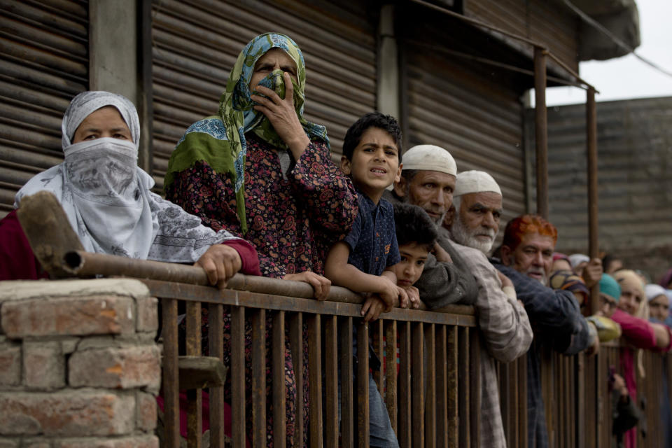 Kashmiri villagers watch funeral procession of top rebel commander Naseer Pandith, in Pulwama, south of Srinagar, Indian controlled Kashmir, Thursday, May 16, 2019. Three rebels, an army soldier and a civilian were killed early Thursday during a gunbattle in disputed Kashmir that triggered anti-India protests and clashes, officials and residents said. (AP Photo/ Dar Yasin)