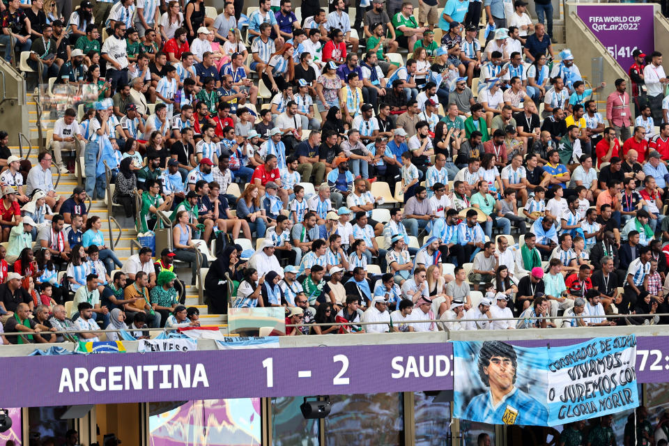 LUSAIL CITY, QATAR - NOVEMBER 22: Fans of Argentina with the scoreboard showing Argentina 1-2 Saudi Arabia during the FIFA World Cup Qatar 2022 Group C match between Argentina and Saudi Arabia at Lusail Stadium on November 22, 2022 in Lusail City, Qatar. (Photo by Matthew Ashton - AMA/Getty Images)