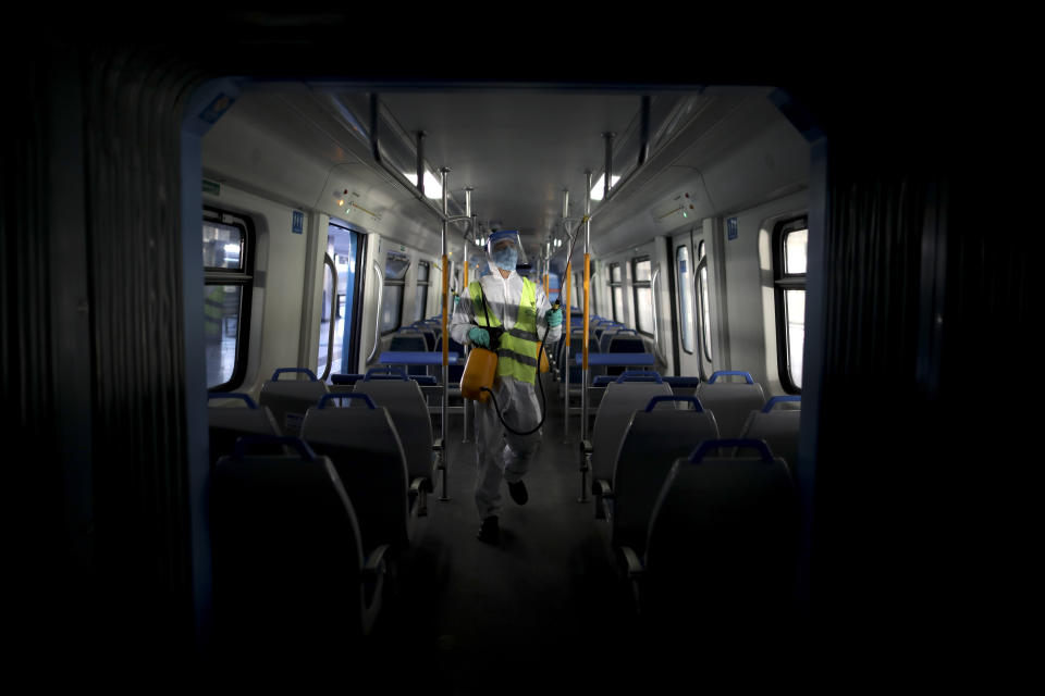 Un hombre desinfecta un vagón de tren en medio de la nueva pandemia de coronavirus, en Buenos Aires, Argentina, el viernes 26 de junio de 2020. (AP Foto/Natacha Pisarenko)