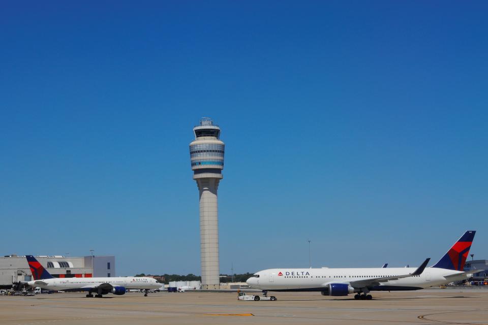 FILE PHOTO: A control tower rises between two Delta Air Lines jets, a Boeing 757-200 and a Boeing 767-300ER, at the Hartsfield-Jackson Atlanta International Airport in Atlanta, Georgia, U.S., April 15, 2019.   REUTERS/Brian Snyder