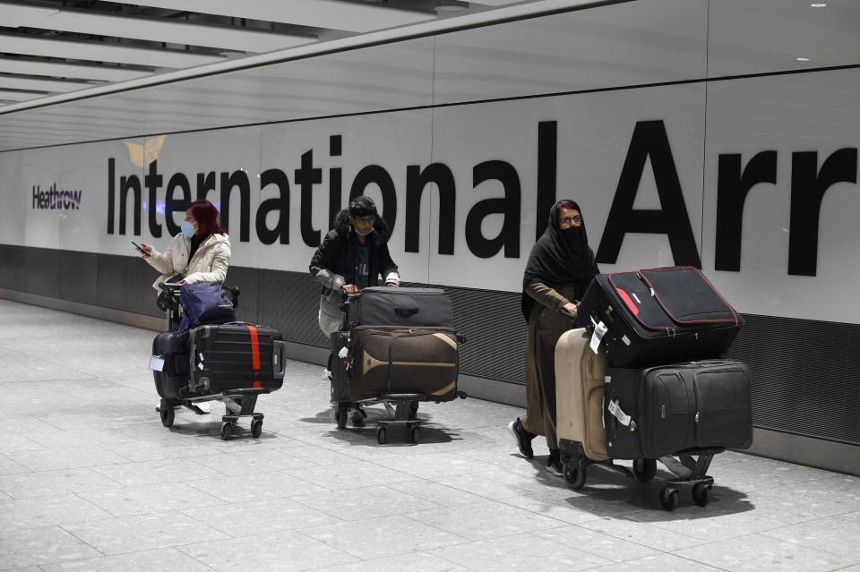 Passengers push luggage through the Arrival Hall of Terminal 5 at London's Heathrow Airport after arriving into the UK following the suspension of the travel corridors. Passengers arriving from anywhere outside the UK, Ireland, the Channel Islands or the Isle of Man must have proof of a negative coronavirus test and self-isolate for 10 days. Picture date: Monday January 18, 2021.